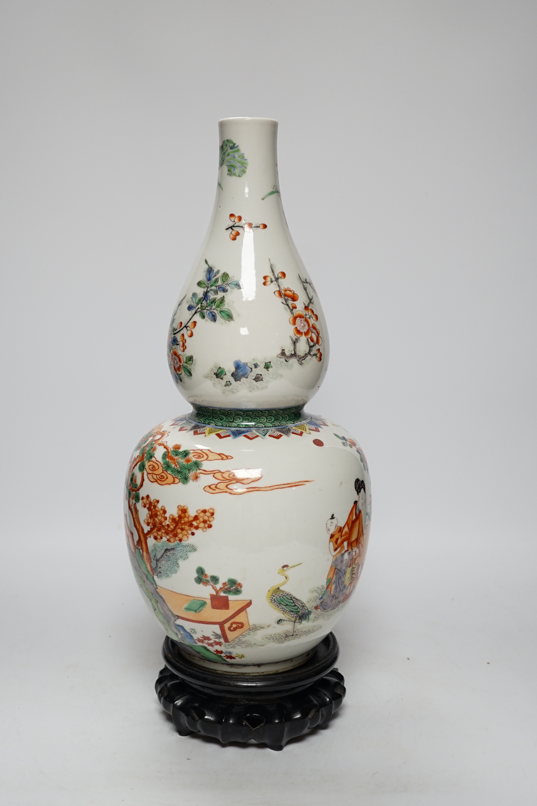 A Chinese enamelled porcelain double-gourd vase on hardwood stand, 41cm total height